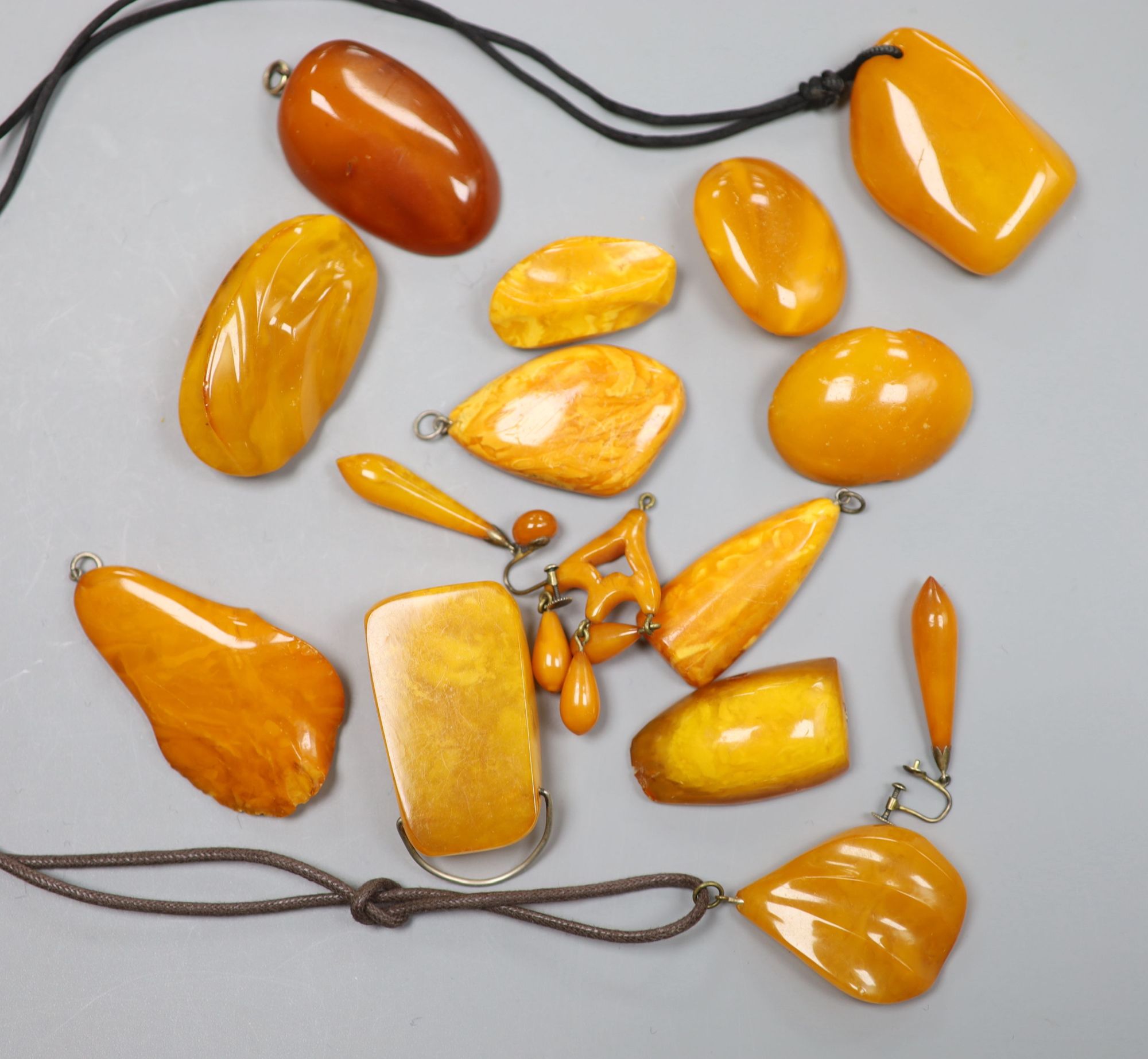 A group of assorted amber jewellery including, earrings, brooches and pendants, gross weight 136 grams.